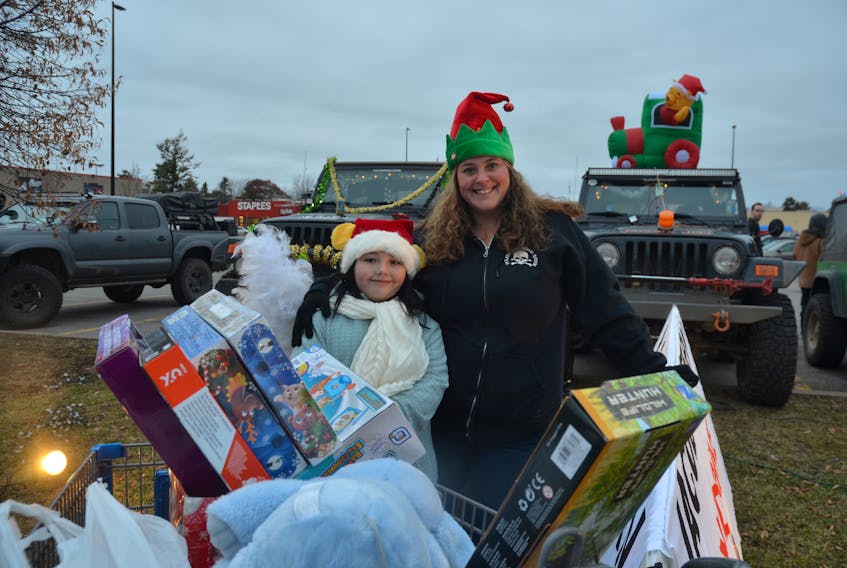Jacob Stern’s eight-year-old sister, Maddie Stern, and his mom, Melissa Benjamin, with a shopping cart load of toys donated as part of a toy drive held in Jacob’s memory.