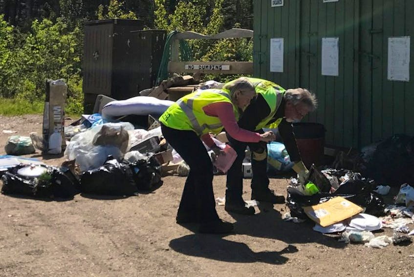 Valley Waste Resource Management bylaw enforcement officer and Nova Scotia Environment inspector Grace Proszynska and waste inspector Carson King conduct an inspection at a cottage bin at Eastside Drive at Aylesford Lake in late May to try to identify the source of material that was illegally dumped.