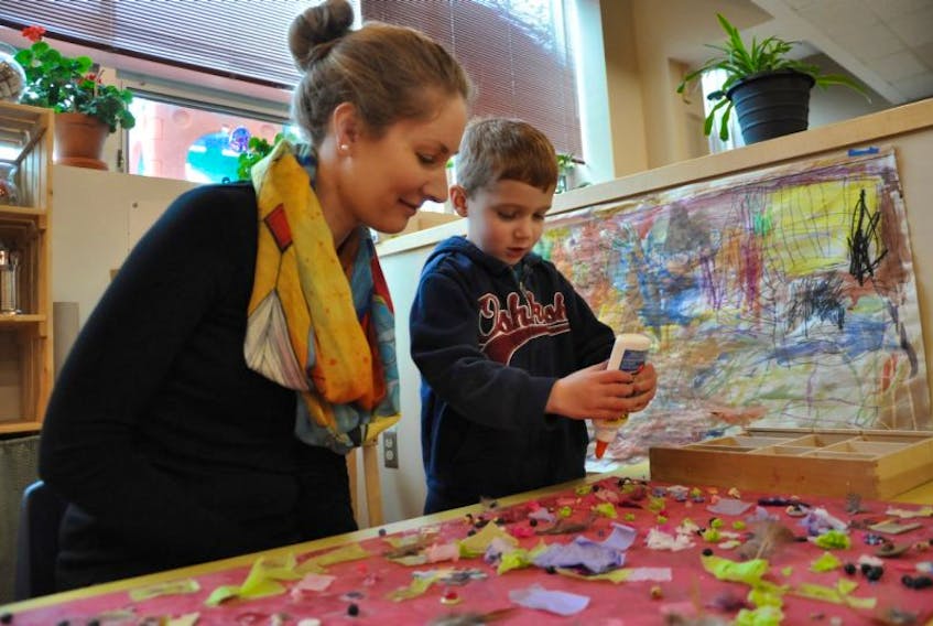 Award-winning early childhood educator Sarah Marshall watches as her son, Evan Marshall, adds his personal touch to a piece of artwork in his classroom at the Kingstec Campus Learning Centre.