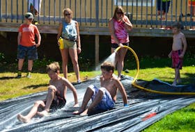 County of Kings summer recreation intern Ashley Brooker keeps the water – and fun – flowing on the soap slide as part of Camp Day.