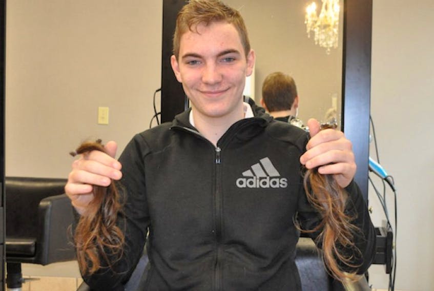 Lucas Stevens of Port Williams shows off the six ponytails left after his first haircut in three years.
