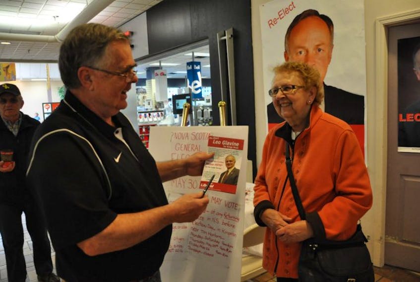 Liberal party supporter John Pierce, campaign manager for Kings West candidate Leo Glavine, shares some campaign literature with Greenwood Mall patron Althea Coleman.