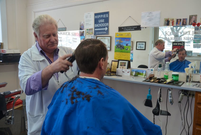 Long-time barber Everett Dixon gives Jeff Wanamaker a haircut at the Kentville Barber Shop on Webster Street.