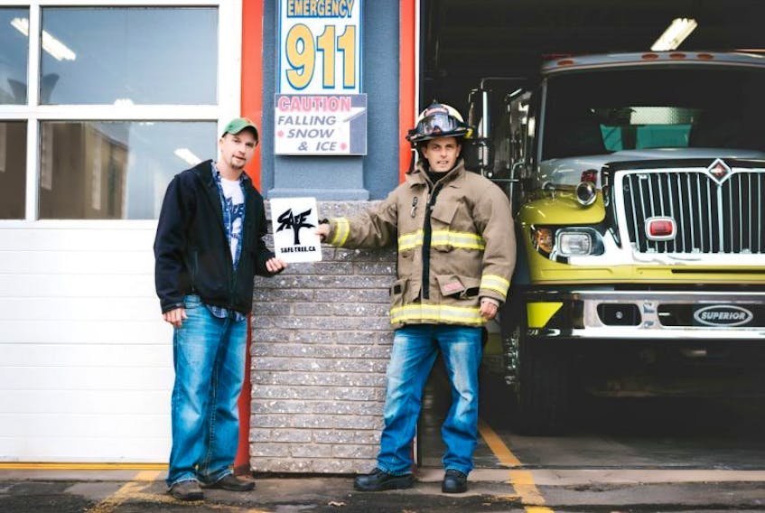 Safe-Tree safety signs founder Tyler Yeaton and Kentville Fire Chief Ryan MacEachern hold up a Safe-Tree sign. Yeaton hopes the signage will eventually become a universally understood symbol.