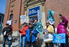 About two dozen people take part in an Extinction Rebellion demonstration in Wolfville on April 18. They are calling on Canada’s large banks to divest from fossil fuel initiatives.
