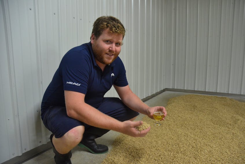 Horton Ridge Malt and Grain Company maltster and assistant brewer Connor Stewart checks on the progress of the grain on the malt floor.