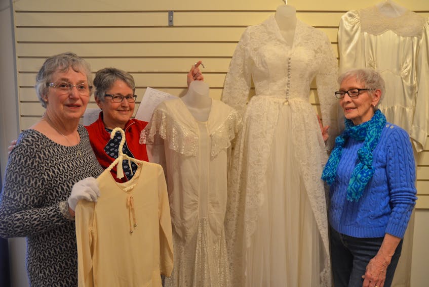 Ruth Butler and Helen Seymour of the Kings Historical Society textile committee and Doris Illsley of the refreshment committee have been busy preparing 20th century wedding gowns for an upcoming exhibit at the Kings County Museum in Kentville.