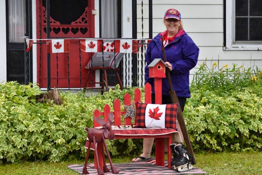 Berwick resident Cheryl Fancey poses with the display she created as part of the town-wide Red Chair Challenge for July 1, a date that has a special place in her heart for a couple of reasons.