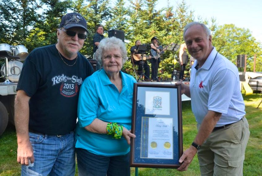 Kings-West MLA Leo Glavine, right, presented Betty Hebb of Millville with a framed certificate of congratulations from the Province of Nova Scotia at the Children’s Wish Foundation fundraising concert at Farmers Family Diner on Aug. 27. Concert promoter Dennis Wilson, left, was on hand to congratulate Hebb.