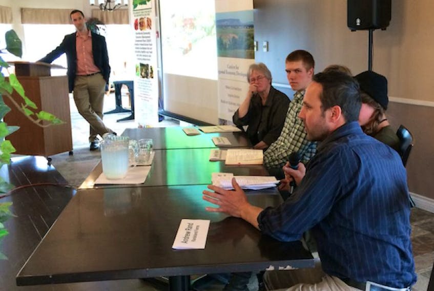 Farmer Andrew Rand, foreground, explains his family's focus on vegetable production during the Regional Enterprise Network panel April 26 on food as a main course for the local economy.