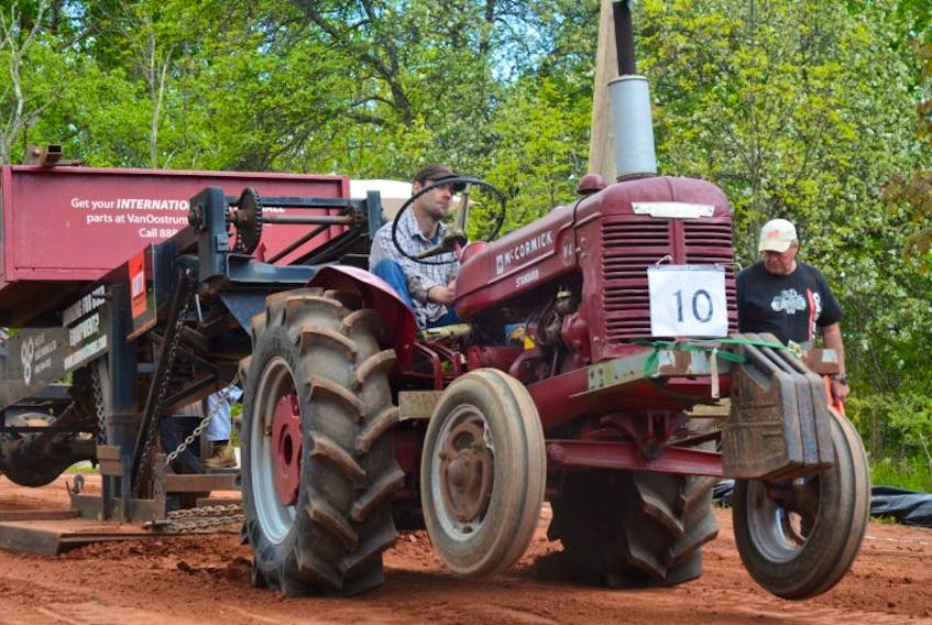 Charles Robinson competes in the 6,000-pound class at the Northville Farm Heritage Centre’s annual Apple Blossom Festival Antique Tractor Pull and Show on May 28. Driving a 1952 McCormick W4, he pulled for 144 feet, nine inches on this run.