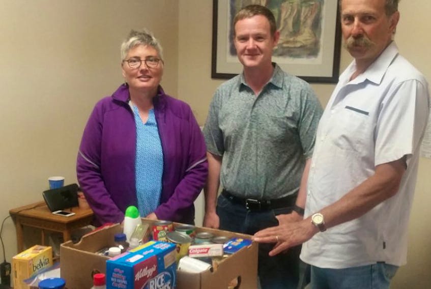 Volunteers Cari Patterson, left, and Tim Amos, right, of the Canning Area Food Bank brought a hamper with them to talk poverty issues with Kings North Liberal candidate Geof Turner.