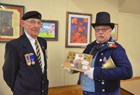 Roy Lynk, past president of the Habitant Royal Canadian Legion Branch 73 in Canning, and Village of Canning town crier Gary Long appreciate the significance of Remembrance Day and commemorating the end of the First World War. Long holds a display honouring the military accolades of his grandfather and a Second World War air raid warden’s bell.