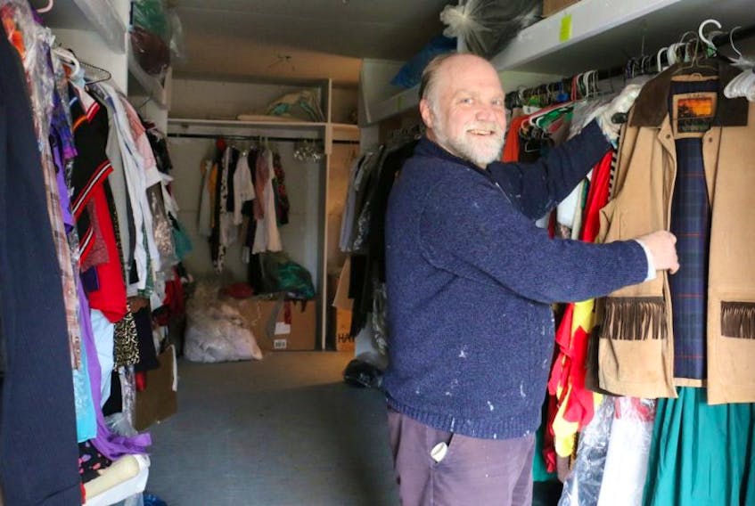 Jim Horne, a board member with Quick As A Wink Theatre, looks at one of the pieces of clothing that was recently hung up in the costume department of the theatre's new building. With hundreds of costumes, Horne said volunteers will soon be tasked with getting them organized.