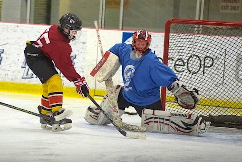 <p><span class="Normal">Goalie Keegan Duffy keeps an eye on Brett Arsenault as the forward tries to score during Charlottetown Abbies peewee AAA practice on Tuesday.</span></p>
