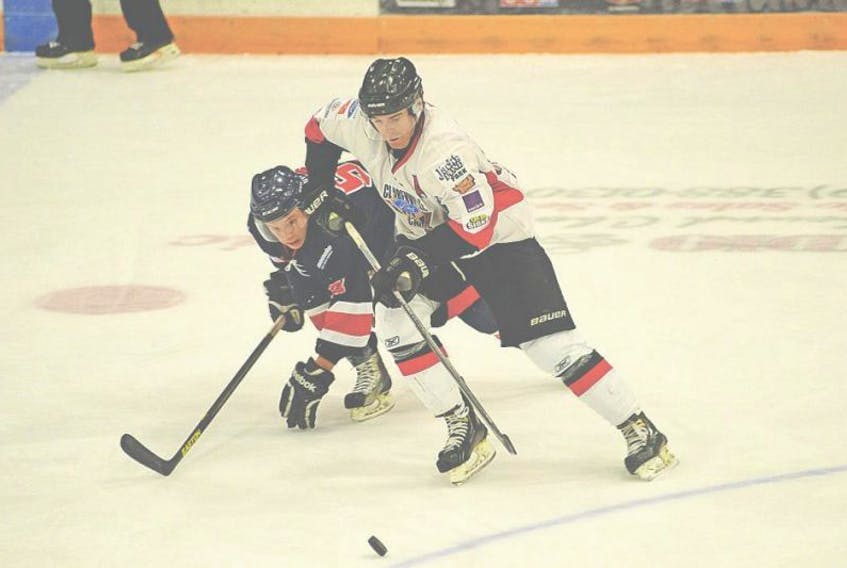 In this Nov. 9, 2014 file photo, Keith Delaney (right) of the Clarenville Caribous and the Corner Brook Royals’ Matthew Thomey compete for the puck during Central West Senior Hockey League action at the Pepsi Centre in Corner Brook. The two are now teammates after a recent trade that sent Delaney from the Caribous to the Royals.