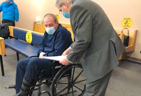 Kenny Green (seated) speaks with his lawyer, John Hartery, during a break in proceedings at provincial court in St. John's Tuesday.