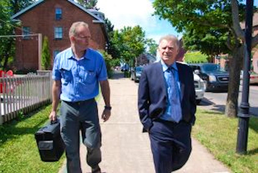 ["Kevin Arsenault, right, leaves the Supreme Court of P.E.i. with his brother, Garth, this morning in Charlottetown. Kevin is seeking a judicial review of the province's abortion policy and laws. A judge will rule on his applcation this afternoon."]