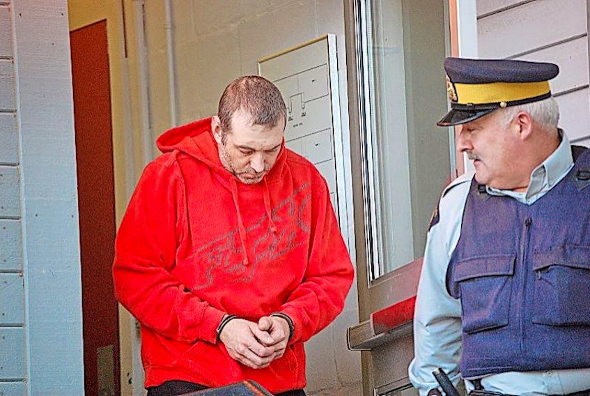 Kevin Lecointre is escorted out of the Stephenville Provincial Court Building by a police officer Thursday.