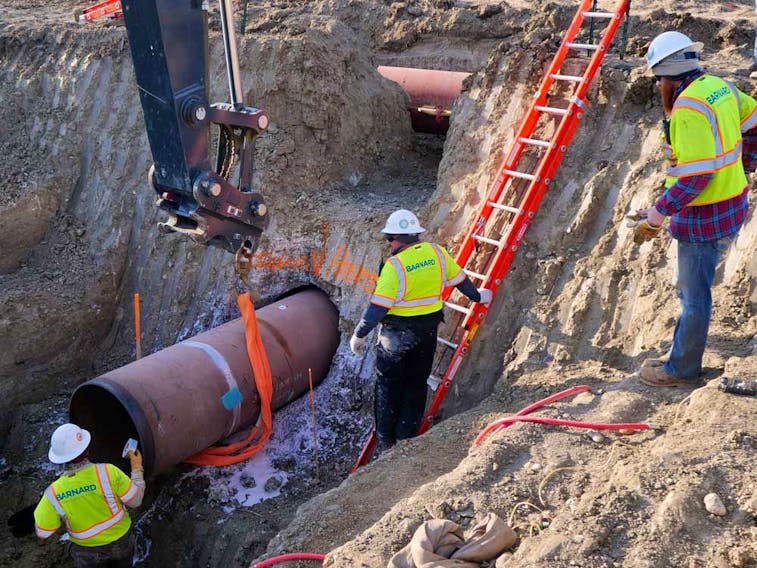 Construction contractors for TC Energy are seen installing a section of the Keystone XL crude oil pipeline at the U.S.-Canada border north of Glasgow, Mont., on April 13, 2020.