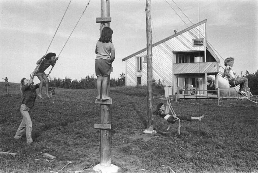 Children play in front of the wood-clad house located in Spry Point in 1974.