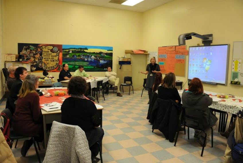 <p>Carolyn Black, standing right, a school counsellor at Kensington Intermediate Senior High School, speaks with a group of community business leaders and educators during a recent meeting at the school to foster closer ties between the two groups.&nbsp;</p>