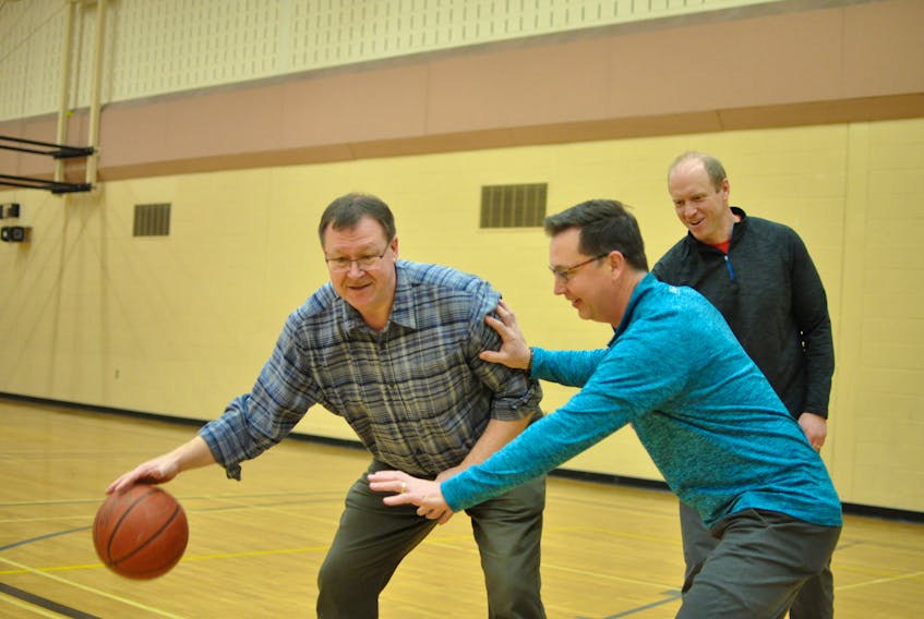Jim Hughes, left, was not letting Glenn Gillard take the ball from him when they played a little one-on-one at Corner Brook Regional High recently. The two will meet on the court on Saturday when Hughes and some other former Regina Knights take on Gillard and some former Herdman Huskies in a “Reviving the Rivalry” basketball game. Shannon Sweetland, centre, is the organizer of the game.
Diane Crocker/The Western Star
