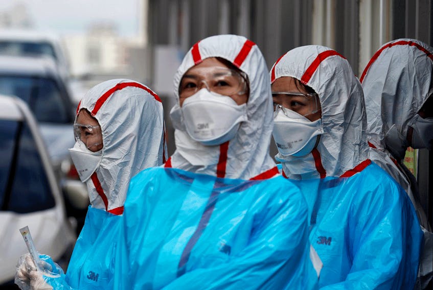  Medical staff in protective gear work at a ‘drive-thru’ testing center for the novel coronavirus disease of COVID-19 in Yeungnam University Medical Center in Daegu, South Korea.