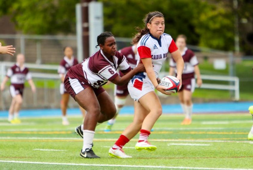 Acadia’s Annie Kennedy avoids a Saint Mary’s player during Sept. 17 action, which saw the rugby Axewomen win 77-7.
