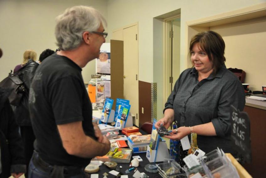 Holly Silver, right, answers questions at the booth she set up for the annual Holistic and Well-Being Expo hosted at the Greenwich Fire Hall May 6.