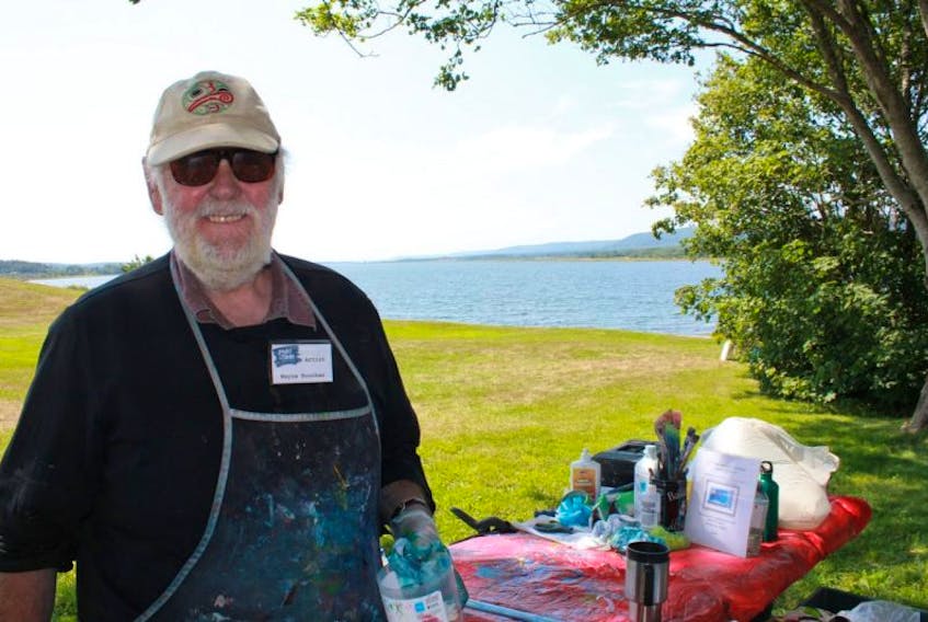 Artist Wayne Boucher smiles for the camera while creating a piece of art for Paint the Town in 2015.