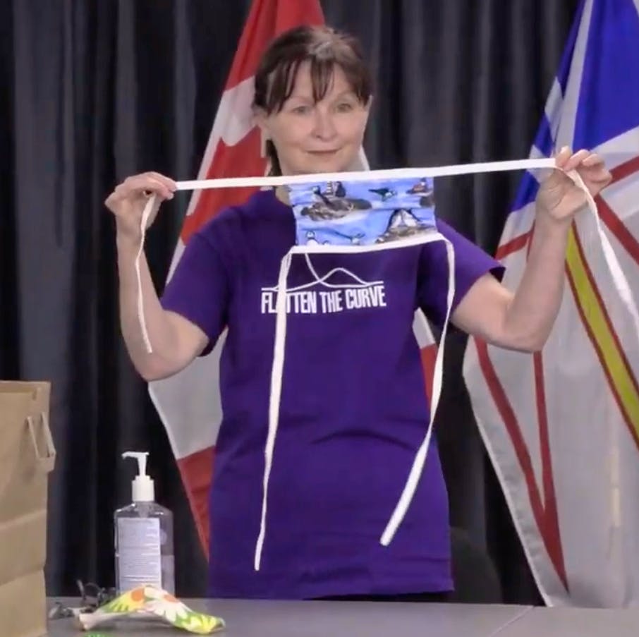 Brenda Earles, infection control nurse specialist with Health and Community Services, demonstrates the proper way to put on and remove a face mask during a COVID-19 briefing in April. Starting Monday the province will make wearing a mask in indoor public areas mandatory. — Image from video.
