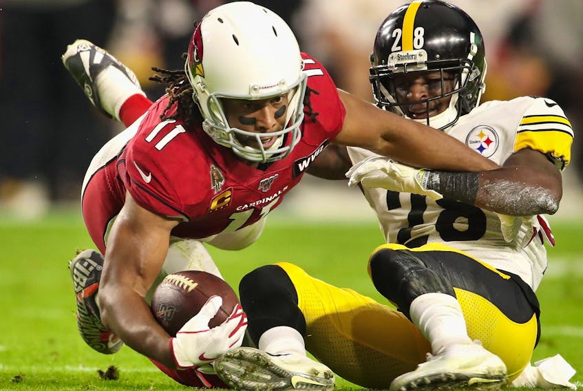 Cardinals wide receiver Larry Fitzgerald makes a reception ahead of Steelers cornerback Mike Hilton. Fitzgerald is feeling much better after beating COVID-19. 