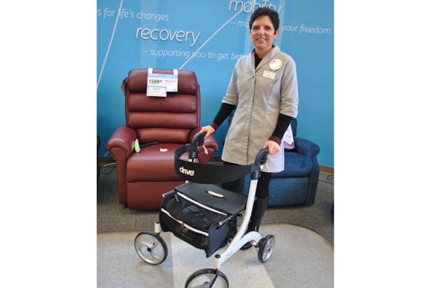 Home health care manager Renee Henderson shows a rolator, which assists seniors with mobility. A lift chair is in the background. These are some of the many products available to help older people continue to live independently.