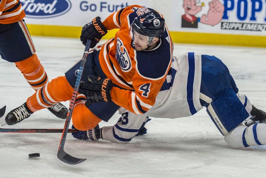Kris Russell (No. 4) of the Edmonton Oilers, clears the puck in front of the net and away from Tyler Ennis (No. 63) of the Toronto Maple Leafs at Rogers Place in Edmonton on March 9, 2018. 