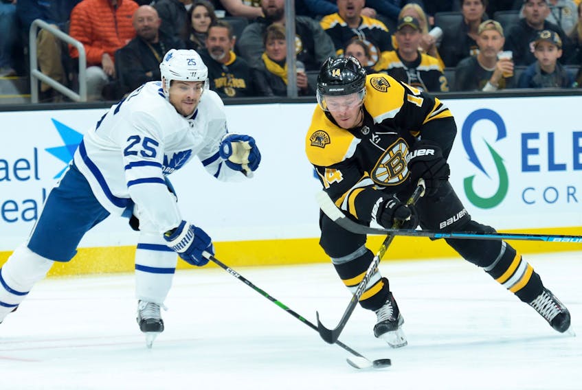 Toronto Maple Leafs defenseman Kevin Gravel, left, pokes the puck away  from Boston Bruins right wing Chris Wagner during the first period at TD Garden in Boston, Oct. 22, 2019. (Bob DeChiara-USA TODAY Sports)