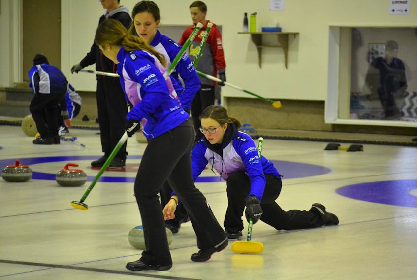 Lead Rachel O’Connor, left, and second stone Breanne Burgoyne prepare to sweep for their skip, Lauren Lenentine during the P.E.I. Pepsi junior curling championships last month in O’Leary. The team’s third stone is Kristie Rogers. They defended their 2017 provincial title, and are competing in their second New Holland Canadian junior curling championships this week in Shawinigan, Que.