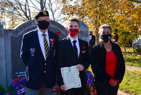 Habitant Legion school liaison Jon VanZoost, left, and newly elected Kings County councillor June Granger present Roman Javorek with a plaque and cheque for placing second nationally in the senior category of the Royal Canadian Legion’s Remembrance Day poetry contest. KIRK STARRATT