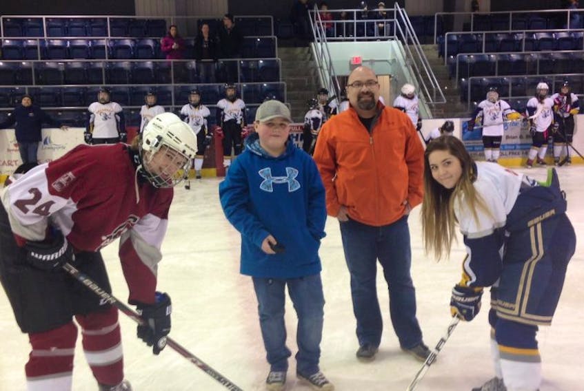 Participating in the ceremonial opening faceoff of the Randy Cuff Memorial Tournament this past weekend were players Mark Holloway (left) from the Bonavista Cabots and Abigail Pardy (right) of the Lewisporte Seahawks. Representing the Cuff family was Craig Cuff (middle right) and his son Randy (middle left). The Bishop’s Falls Express came out on top and took home the banner.