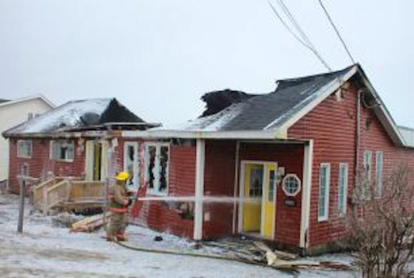 ['A firefighter from Lewisporte Fire Rescue identified areas from an overnight house fire that required attention. The fire department returned to the scene just after 11 a.m. to address a flare up situation from the house fire at 263 Main Street.']