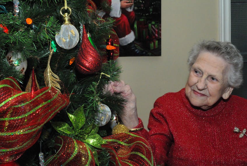 One-hundred year-old Ida Peet, a resident of Meadow Creek Retirement Home in Paradise, hangs a bulb on the Christmas tree in the building’s lobby as part of the Kirby Retirement Living’s Lighting Up the Homes celebrations across the province. — Joe Gibbons/The Telegram
