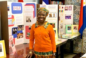 Lloydetta Quaicoe poses in front of students’ culture projects at the Sharing Our Cultures office in St. John’s. She says it’s important for children to celebrate their identities. – ROSIE MULLALEY/The Telegram