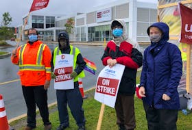 Dominion workers were dressed for wet weather outside the Blackmarsh Road location on Sunday. -JUANITA MERCER/THE TELEGRAM