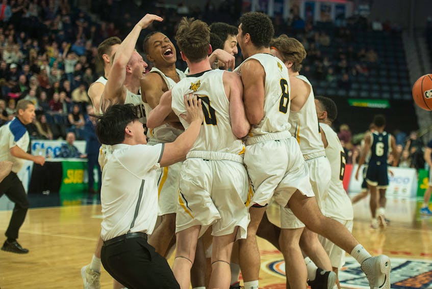 The Dalhousie Tigers celebrate their 76-64 victory over the St. F.X. X-Men in the men’s basketball AUS Championships final at the Scotiabank Centre on Sunday, March 1. (RYAN TAPLIN/Chronicle Herald)
