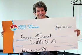 Gary McCourt of Kensington holds a symbolic cheque representing his $100,000 Atlantic Lottery win in this photo provided by the corporation.