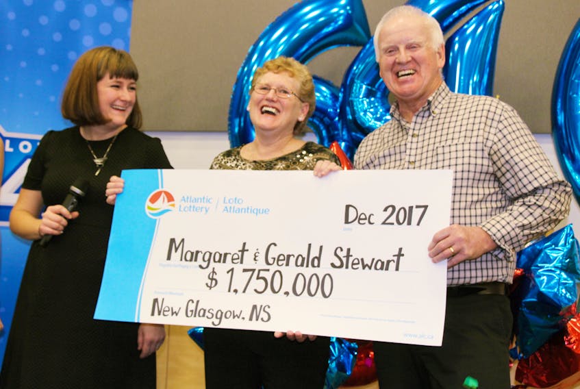 Natalie Belliveau of Atlantic Lottery presents Margaret and Gerald Stewart with their $1.75 million cheque. - Sueann Musick