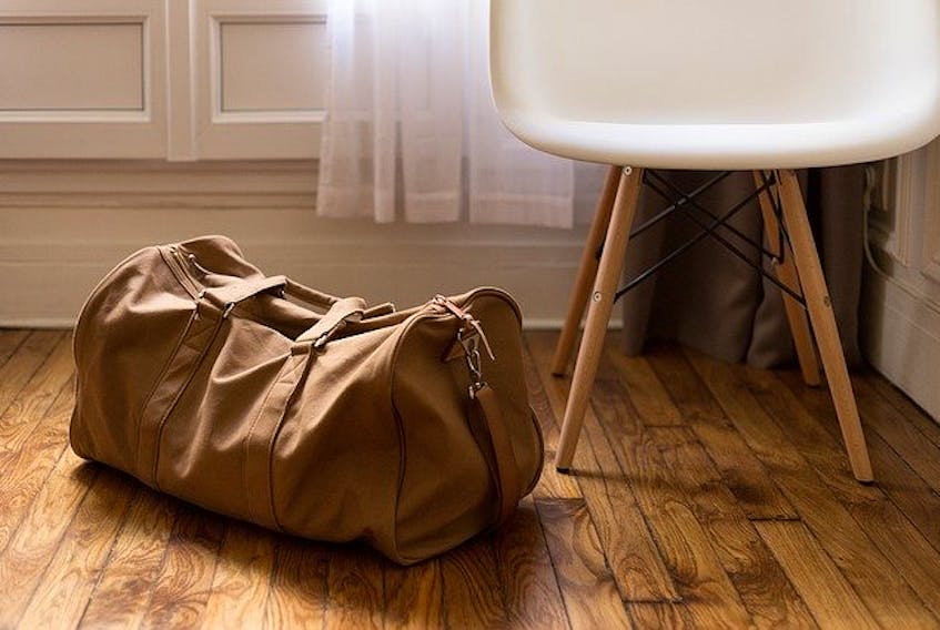 Stock image of luggage next to a chair.