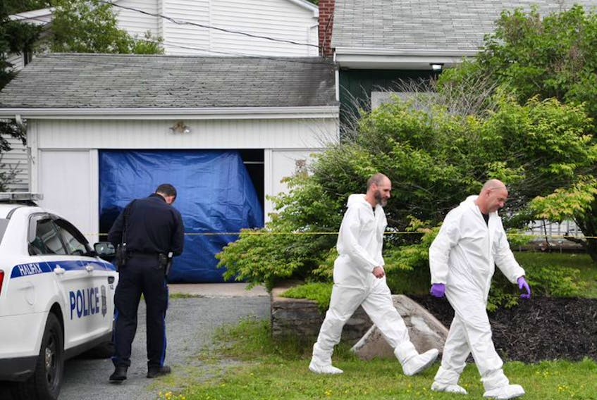 Members of the Halifax regional police forensic identification service walk toward a Lynwood Drive home in Dartmouth on Sunday, July 12, 2020. Police were at the residence for a second straight day in a continuing investigation into the suspicious death of an 85-year-old woman.
