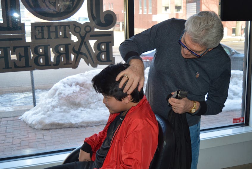 On Wednesday, Charlottetown barber Joe Punzo and his wife cancelled a trip back to their native Italy after the country went into lockdown due to the coronavirus outbreak, a situation that is affecting the travel plans of many Islanders. Here, Punzo prepares to give John Lim of Summerside a trim. Dave Stewart/The Guardian