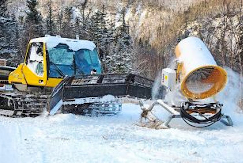 ['GERALDINE BROPHY/THE WESTERN STAR<br />Tony Abbott, operations manager with Marble Mountain, hooks up another snow gun to tow up the mountain Wednesday. The ski facility has 21 snow-making machines, the last three of which was put in place Wednesday.']